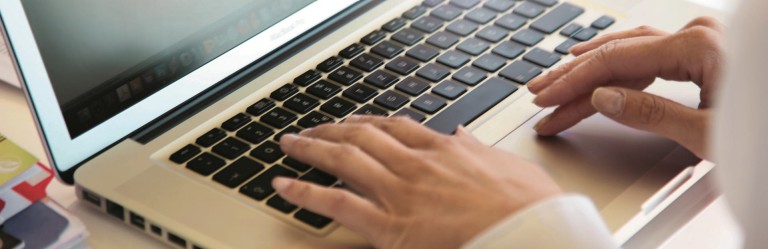 Laptop, Damenhände die auf der Tastatur tippen